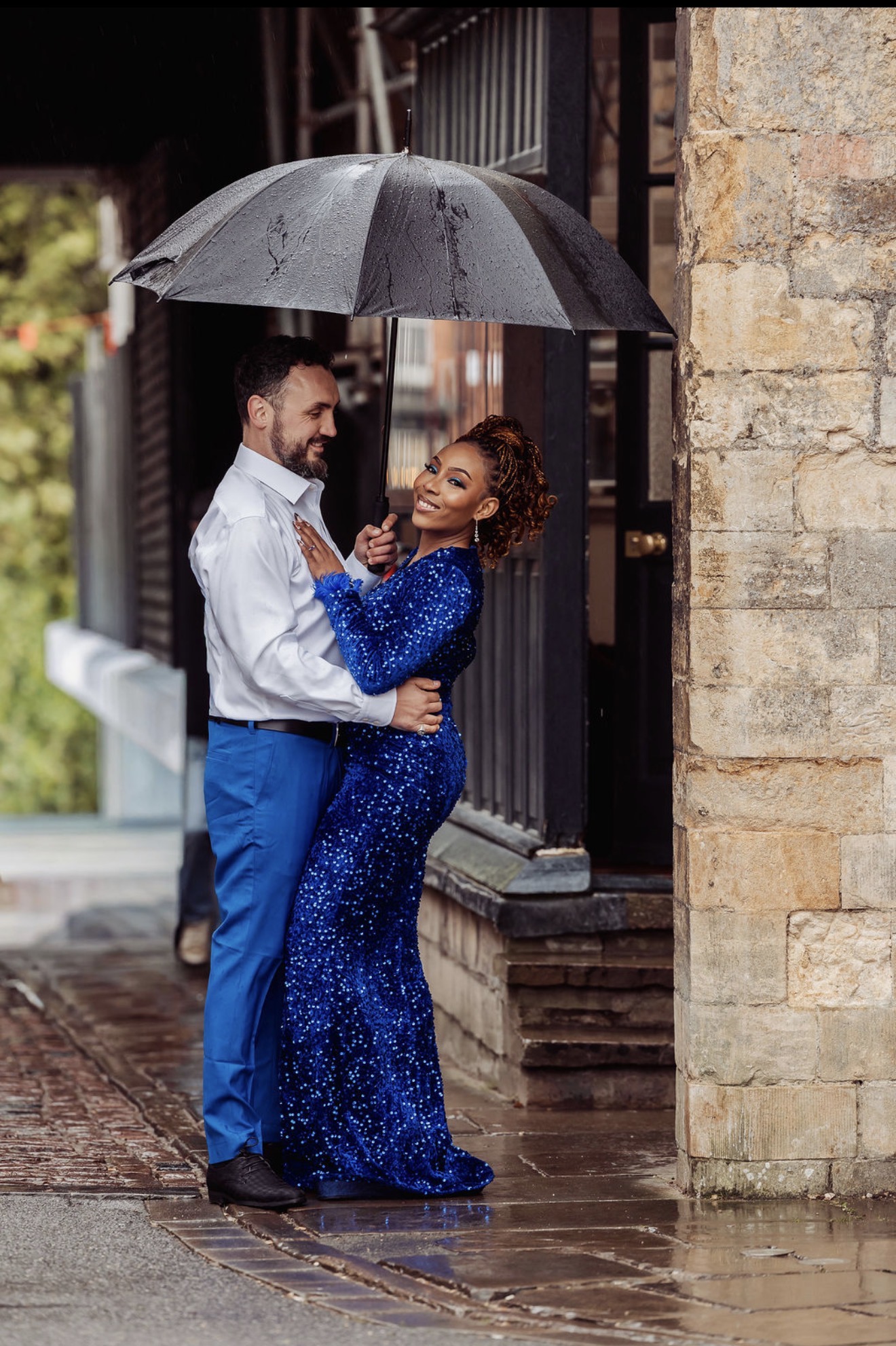 Gabriella and Elliott share an umbrella as rain falls on their pre-wedding shoot. Photograph: Thomasxphotography