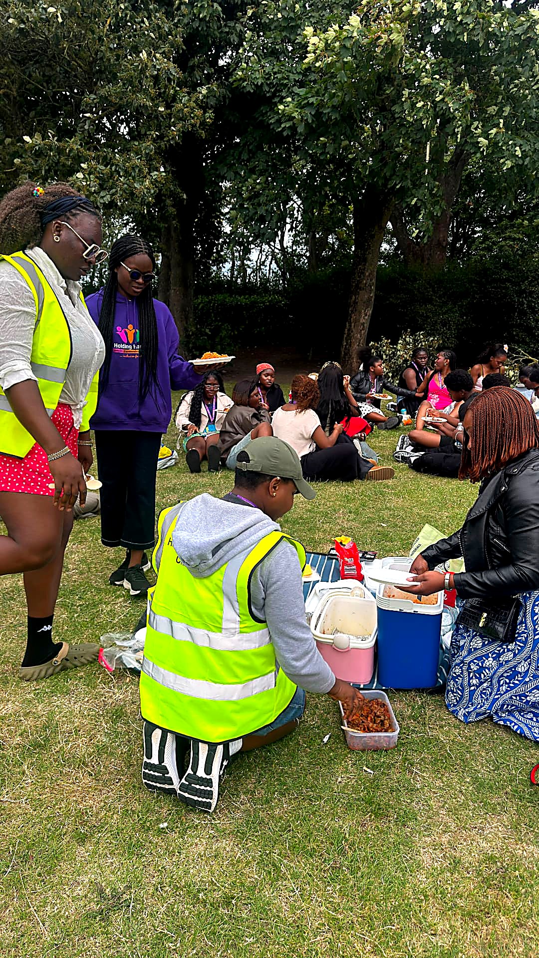 Volunteers serve food during the picnic in the nearby gardens.