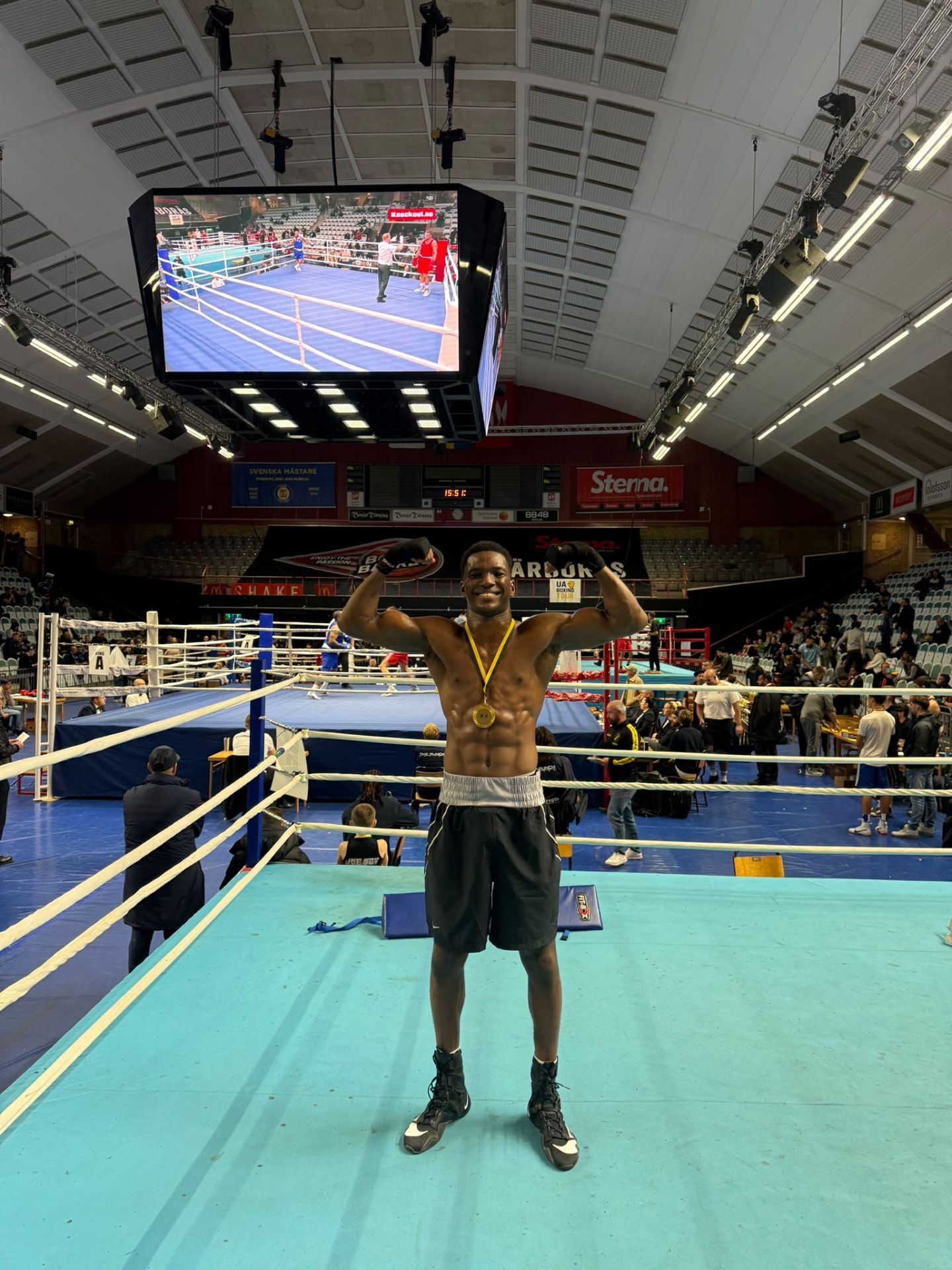 Divine Omojor poses with his medal in the boxing ring. Photograph: Supplied